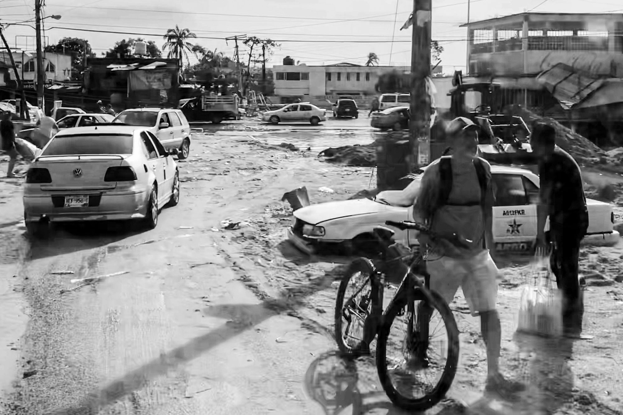 desperate people and broken cars in the mud flooded streets of acapulco damaged by the hurricane otis