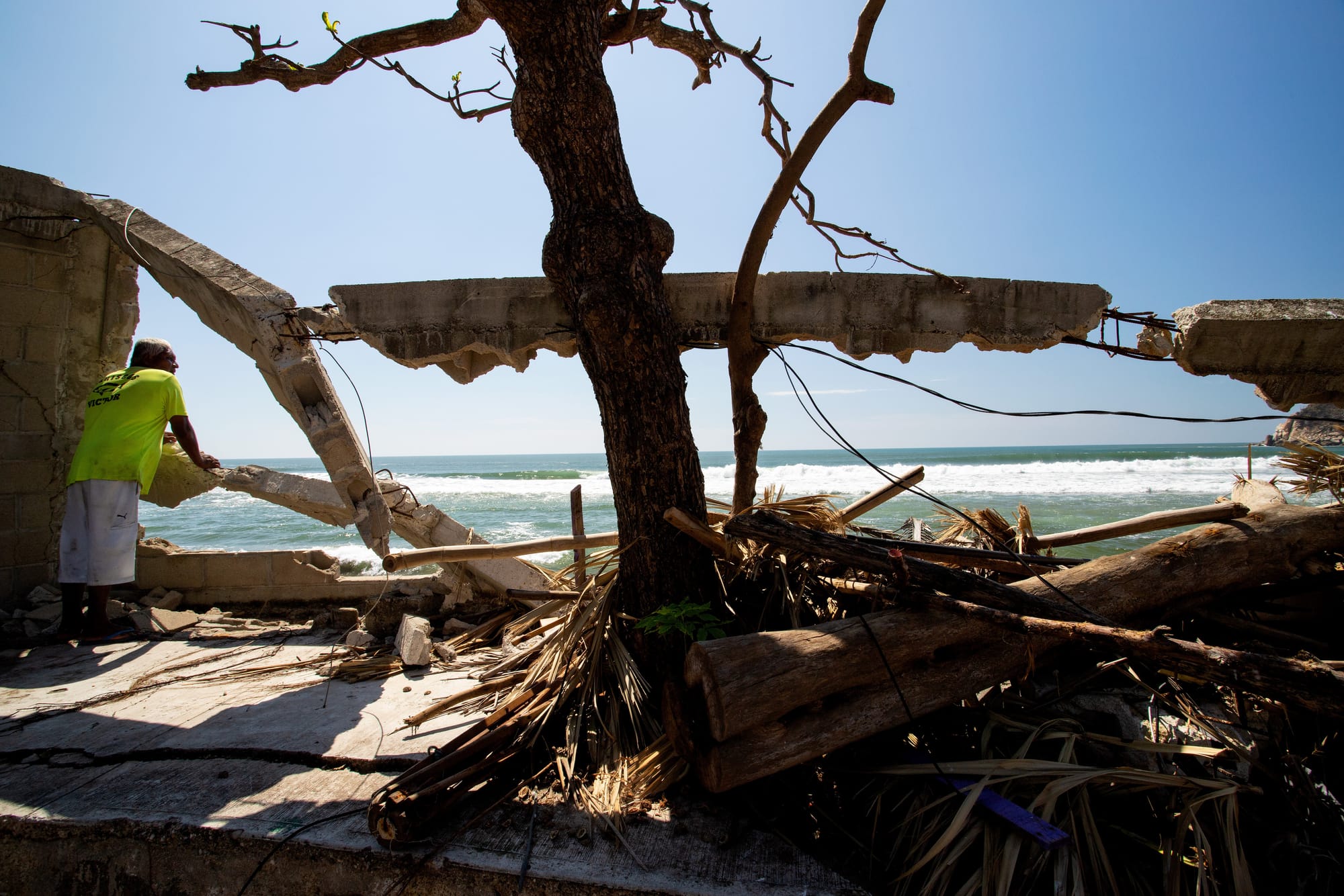 The man looks out towards the place where he ran his business. Now it is destroyed by the hurricane otis