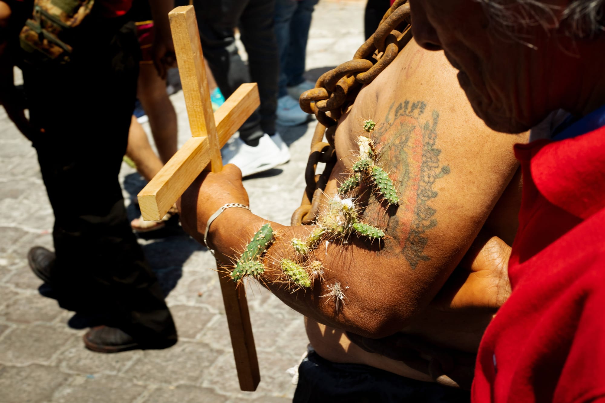 Mexican man in chains, with cross and thorns crown walking through streets of Atlixco, Puebla as a part of local semana santa tradition called los engrillados.